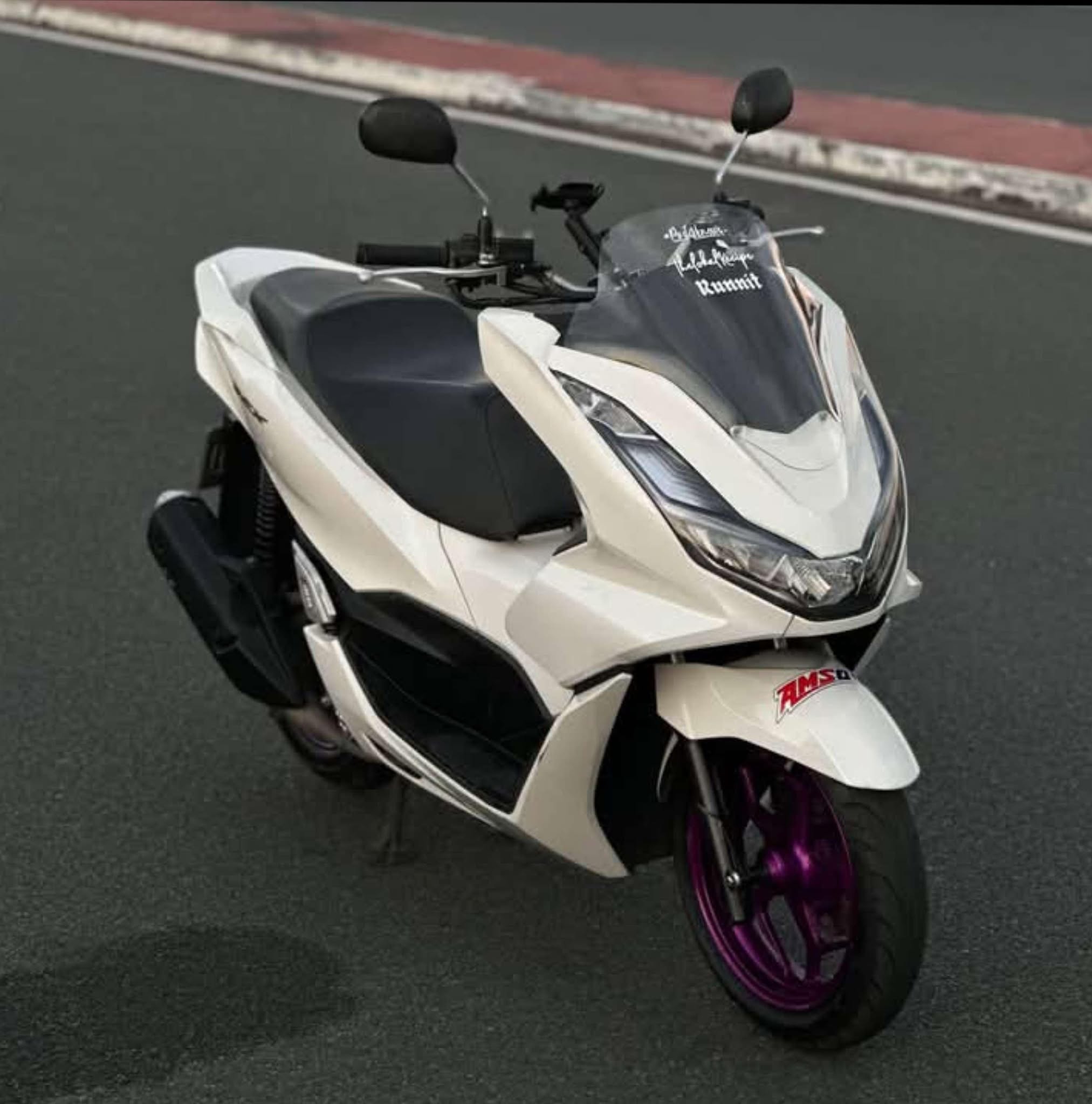 White electric motorcycle model E5 with sleek modern design and digital dashboard